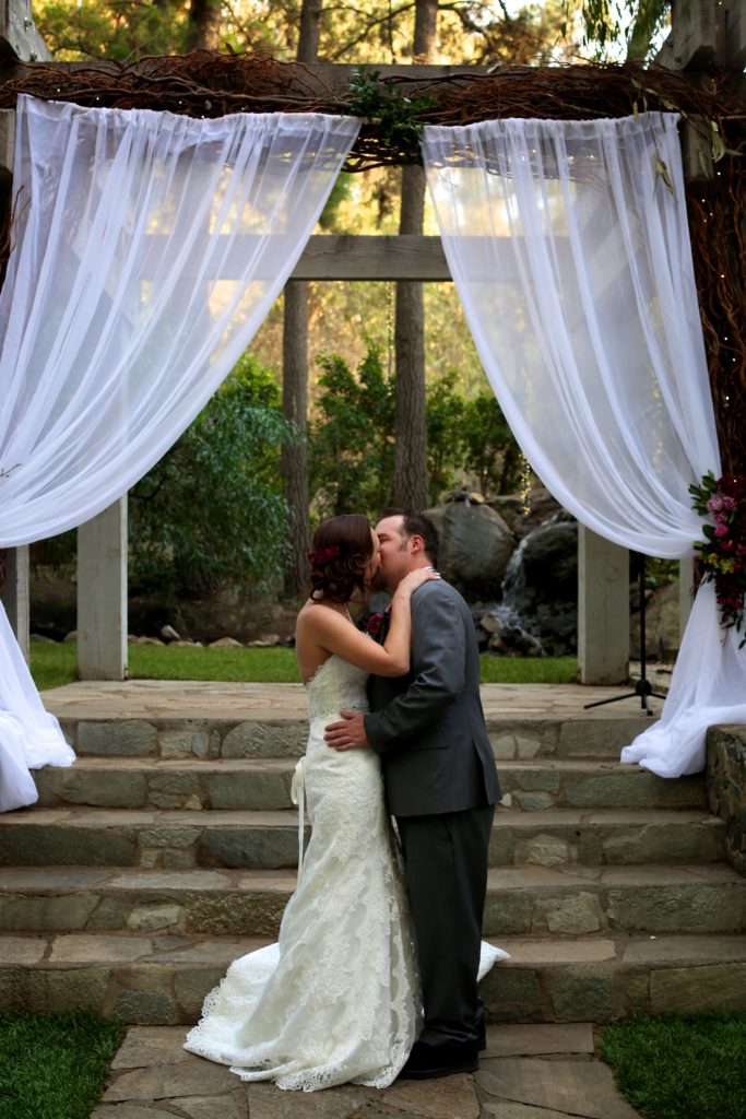 Rustic fall wedding at Calamigos Ranch, bride and groom kiss at altar
