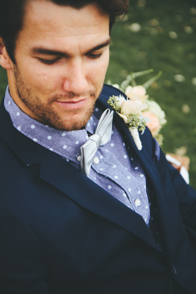 Rustic elegant styled wedding shoot, groom wearing dark navy suit with bowtie and rose boutonnierre