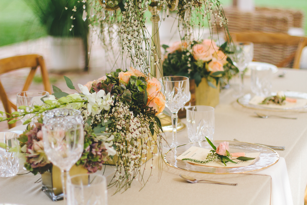 Rustic elegant styled wedding shoot, vintage flower vases with peach floral centerpieces