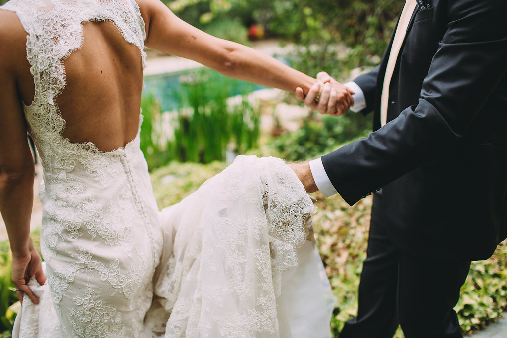 A garden wedding at Mermaid Mountain Inn, groom holding bride's dress