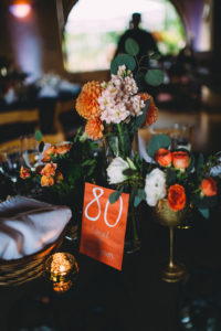 A garden wedding at Mermaid Mountain Inn, reception tables with dark blue, gold and orange