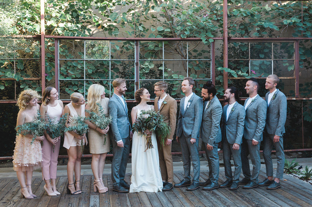 Unique wedding at Elysian LA, wedding party with mismatched blush bridesmaid dresses, grey groomsmen suits, brown groom suit
