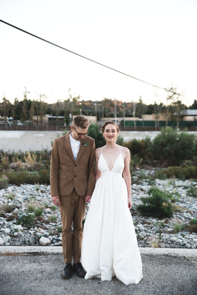 Unique wedding at Elysian LA, bride and groom portrait with groom in brown suit and glasses, bride with simple white dress and red lipstick