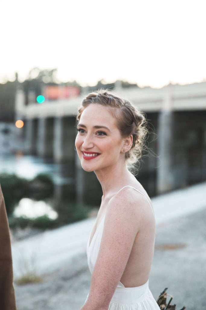 Unique wedding at Elysian LA, bride and groom portrait with groom in brown suit and glasses, bride with simple white dress and red lipstick, classic bride look with braided crown hair and red lipstick