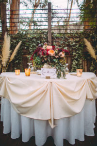 Fall Wedding at Calamigos Ranch, sweetheart table with maroon and blush flowers