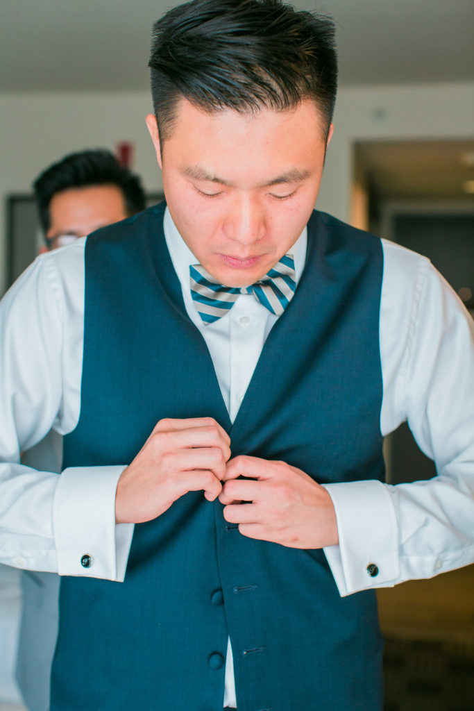 Modern and Chic wedding at Garland Hotel, groom getting ready in suit with striped bowtie