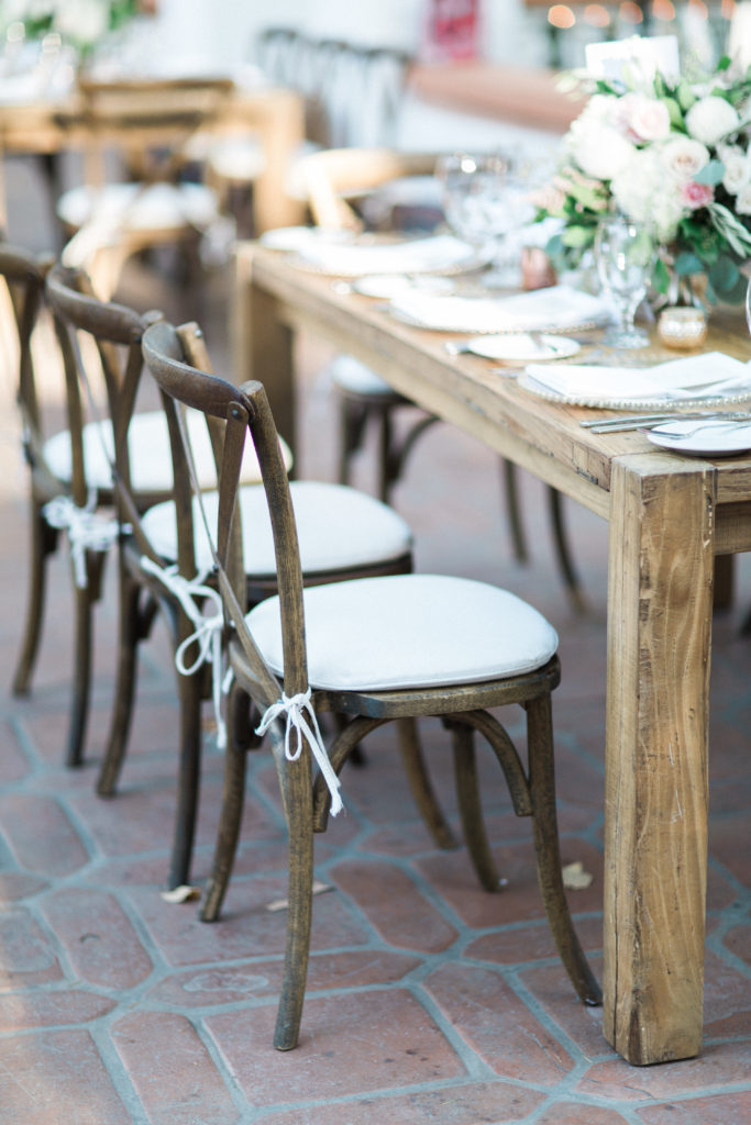 Rancho Las Lomas wedding reception with farm tables and natural wood cross back chairs