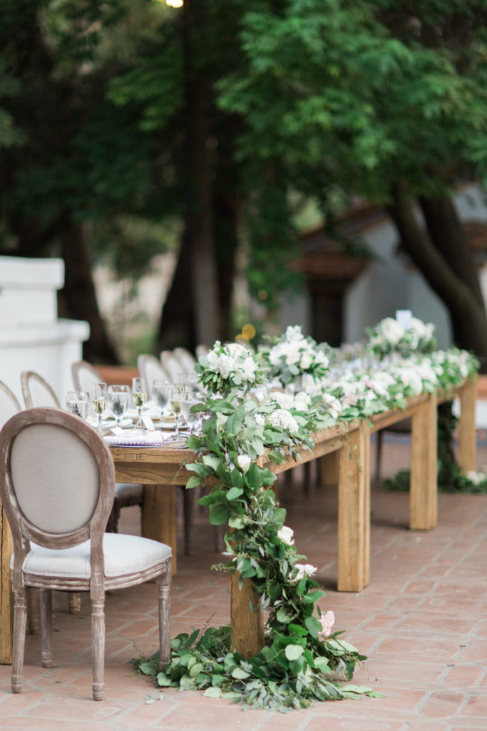 Rancho Las Lomas wedding reception, farm tables with garland centerpiece