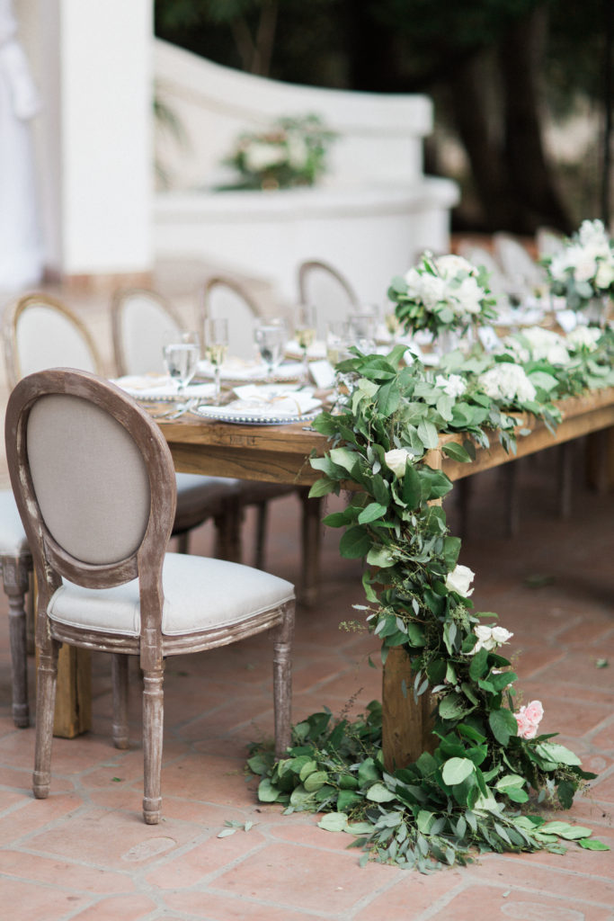 Rancho Las Lomas wedding reception, farm tables with garland centerpiece