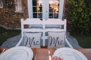 Saddlerock Ranch wedding sweetheart table with "mrs and mrs" pillows