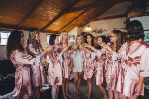 bride with bridesmaids getting ready for wedding