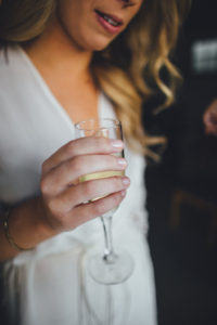 bride drinking champagne while getting ready