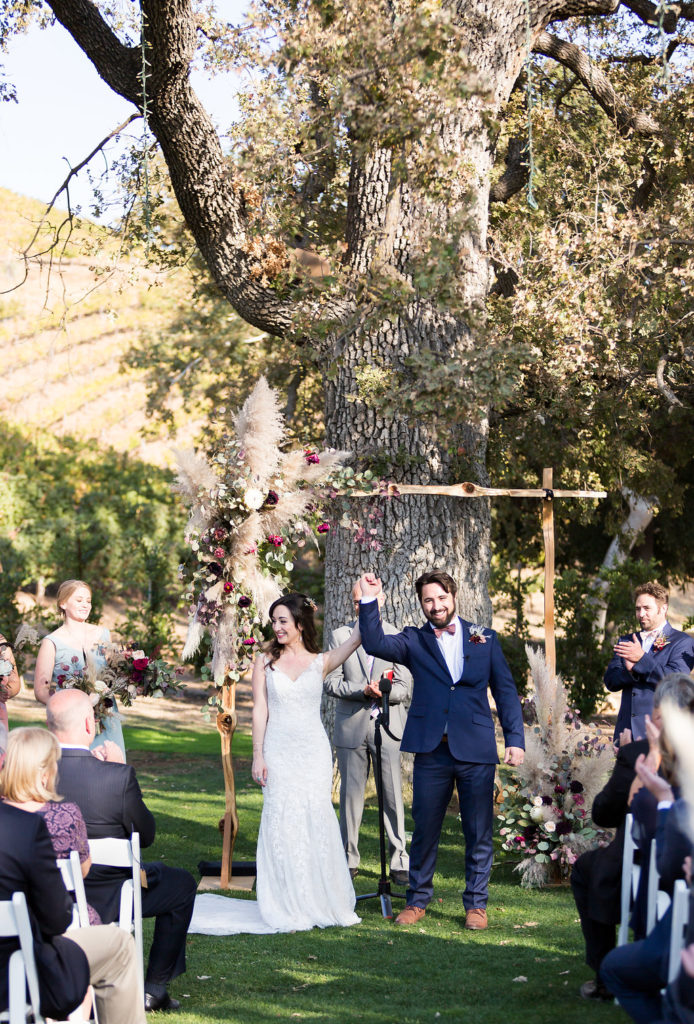 Wedding ceremony at Triunfo Creek Vineyards with wooden arch