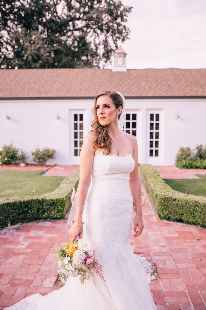 Bridal Photo with flowers in front of the farmhouse at Triunfo Creek Vineyards