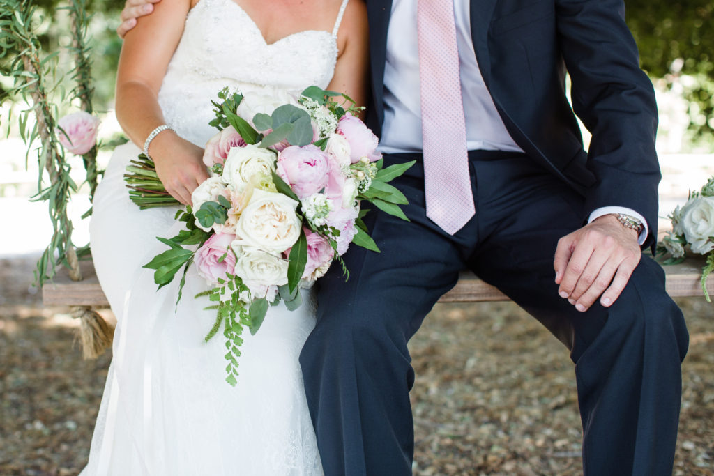 Triunfo Creek Vineyards wedding bride and groom on swing with a blush bridal bouquet and blush grooms tie