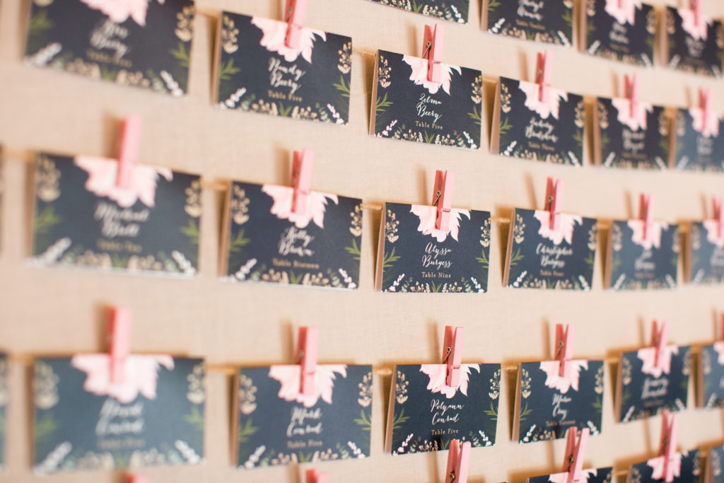 blush and navy wedding place cards on an escort board