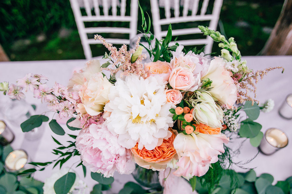 Rancho Buena Vista Adobe wedding reception sweetheart table with pink orange and white flowers