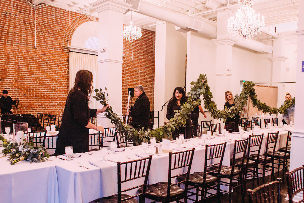 How to work as a team with other wedding vendors, floral team putting garland on the table