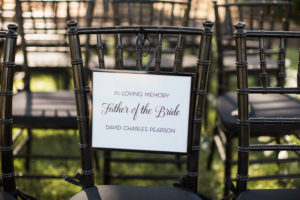 Sogno del fiore wedding ceremony in Santa Ynez winery with black chivari chairs and white flowers, reserved chair sign for deceased family member
