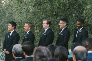 Ace Hotel wedding in Palm Springs wedding ceremony, groomsmen in black suits with succulent boutonniere