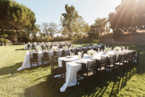 Sogno del fiore wedding reception in Santa Ynez winery, long tables with white tablecloths and black chivari chairs