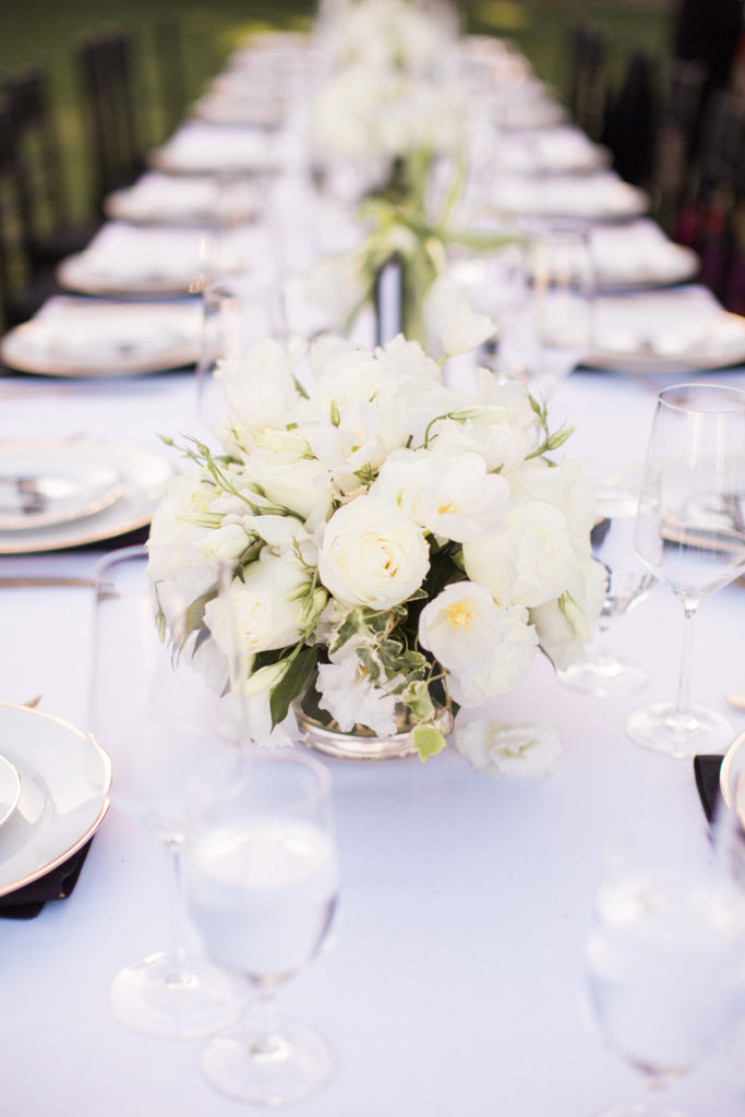 Sogno del fiore wedding reception in Santa Ynez winery, long tables with white tablecloths and black chivari chairs and all white flower centerpieces