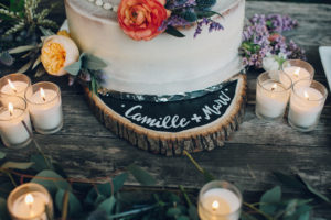 A desert wedding in Ojai at Red Tail Ranch, wedding cake with orange flowers and wooden name sign