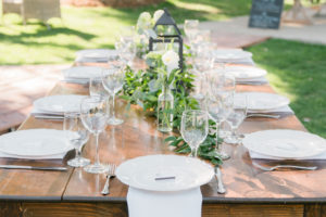 Elegant fall wedding reception at Triunfo Creek Vineyards with white and green florals and a lantern