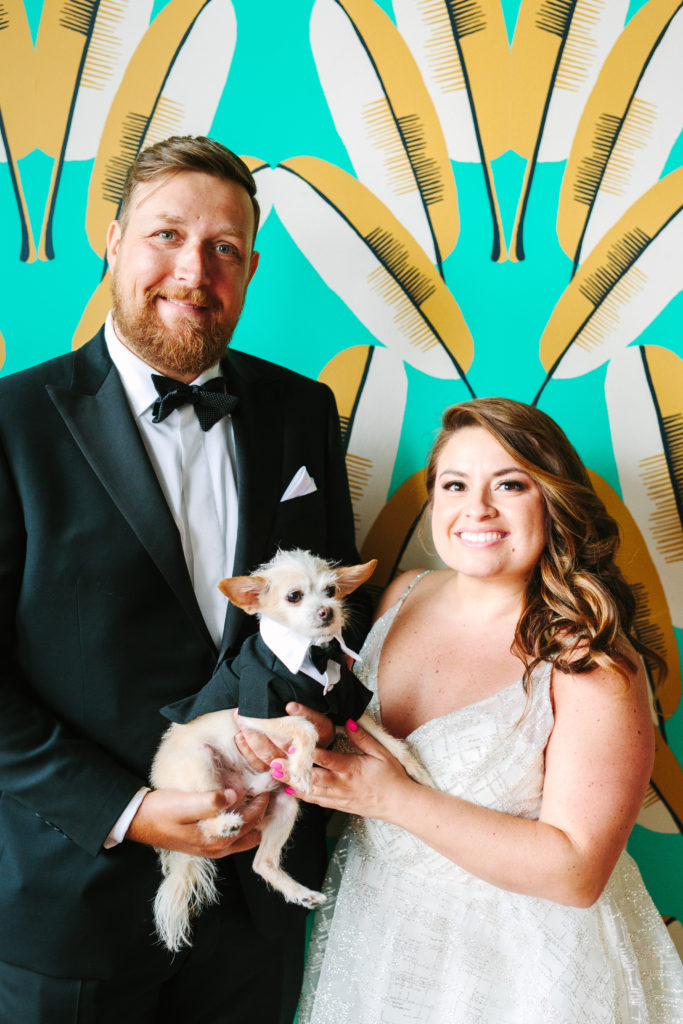 A colorful wedding at Unique Space LA, bride and groom portrait shot with dog wearing tuxedo