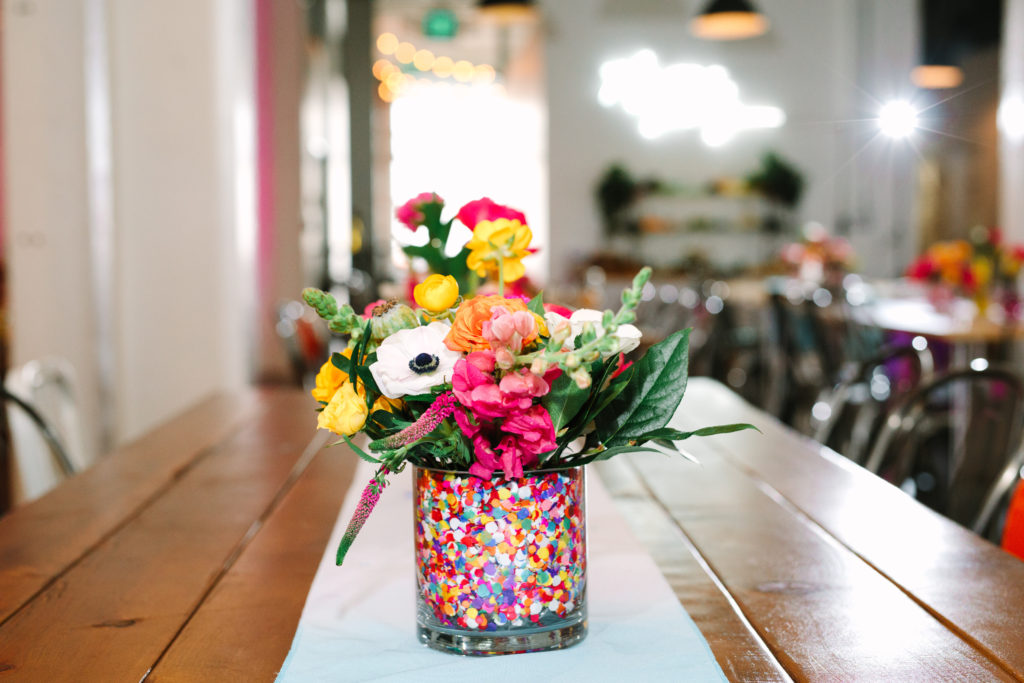 A colorful wedding at Unique Space LA, colorful mismatched confetti filled floral centerpieces