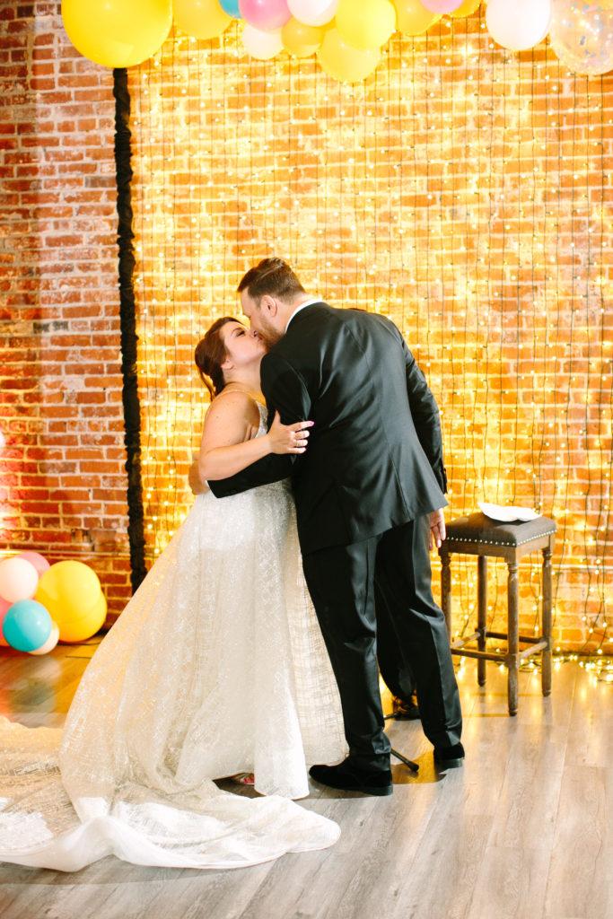 A colorful wedding ceremony at Unique Space LA, bride and groom first kiss