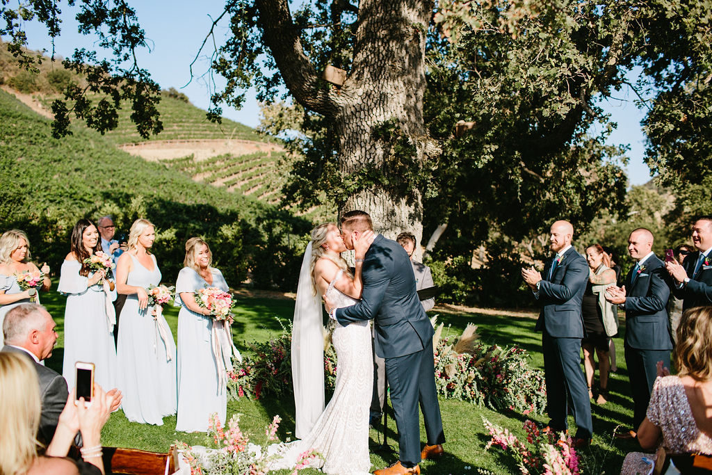 bride and groom kiss during wedding ceremony at Triunfo Creek Vineyards