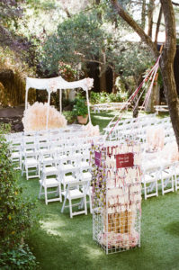 east coast meets west coast wedding ceremony at Calamigos Ranch with lace chuppah and pampas grass aisle flowers and a love lock bridge inspired escort board