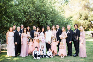 bride and groom with wedding party in mismatched pink bridesmaid dresses and black tuxedo at east coast meets west coast wedding at Calamigos Ranch