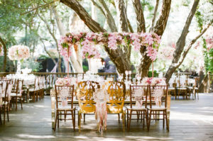 east coast meets west coast wedding reception at Calamigos Ranch with pale pink floral centerpieces in tall glass vases