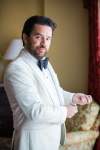 French Groom in white tuxedo with black bow tie for east coast meets west coast wedding at Calamigos Ranch