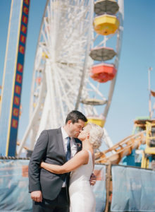 A glam and California infused wedding at Viceroy Santa Monica, bride and groom portrait shot in front of ferris wheel on Santa Monica pier