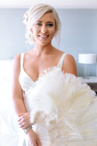 A glam and California infused wedding at Viceroy Santa Monica, bride getting ready wearing silk slip wedding dress and a feathered fan