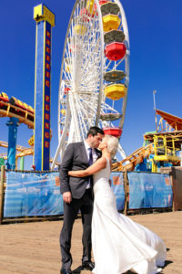 A glam and California infused wedding at Viceroy Santa Monica, bride and groom in front of ferris wheel on Santa Monica pier