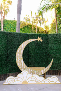 A glam and California infused wedding ceremony at Viceroy Santa Monica with gold moon backdrop