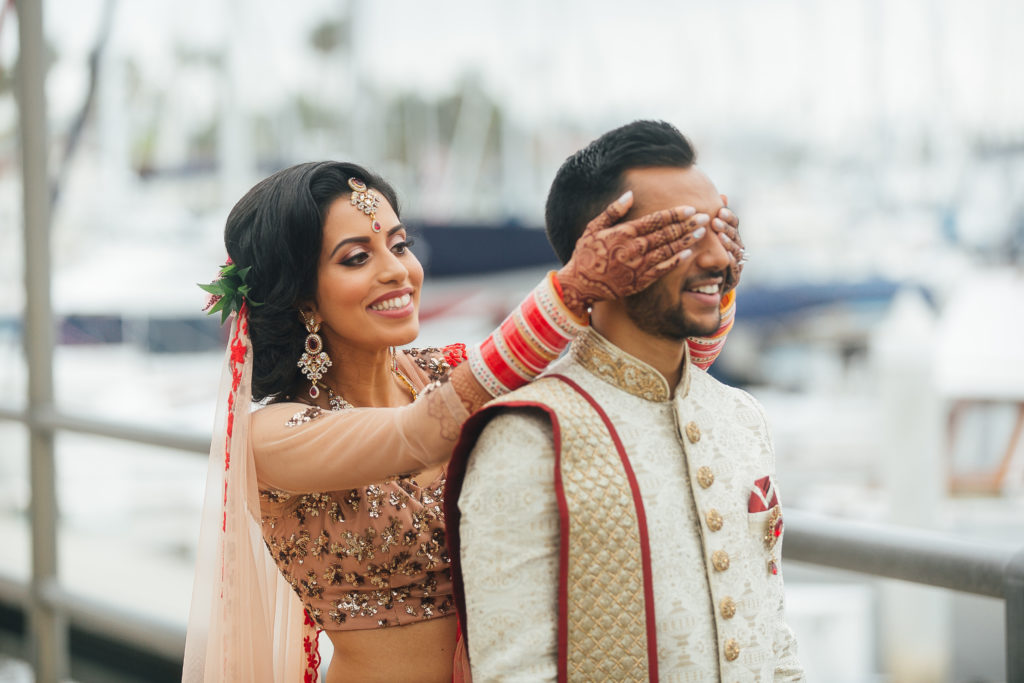 Stunning Indian Wedding in San Pedro, bride in gold and red wedding sari and groom in gold sherwani, bride and groom first look
