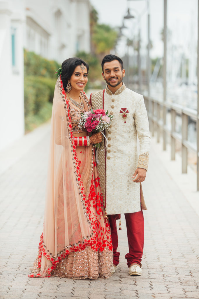 Stunning Indian Wedding in San Pedro, bride in gold and red wedding sari and groom in gold sherwani, bride and groom portrait shot
