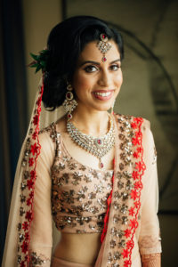 Stunning Indian Wedding in San Pedro, bride in gold and red wedding sari getting ready, bridal hair and makeup