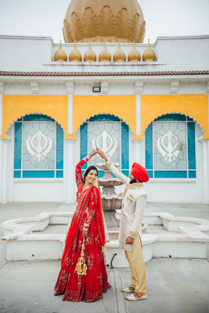 Stunning Indian Wedding in San Pedro, red bridal sari and groom in gold sherwani for sikh ceremony, bride and groom portrait shot