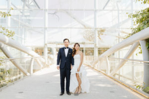 bride in modern hi-low wedding dress and groom in classic black tuxedo at this contemporary wedding at the Natural History Museum in Los Angeles