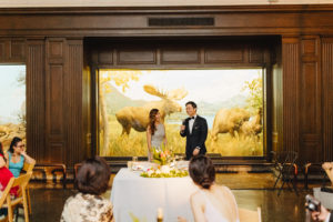 bride and groom speech in front of moose exhibit at contemporary wedding at the Natural History Museum in Los Angeles