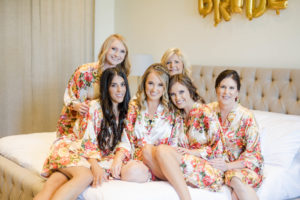 bride getting ready with her bridesmaids wearing floral robes at Calamigos Ranch