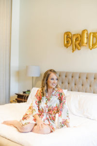 Bride getting ready for wedding wearing a floral robe