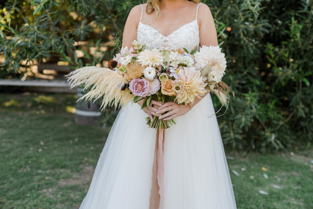 A chic rustic wedding at Calamigos Ranch, dahlia and wildflower bridal bouquet with taupe ribbon