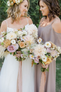 A chic rustic wedding at Calamigos Ranch, bridal bouquet and bridesmaid bouquet with dahlia, wildflowers and pampas grass with taupe ribbon